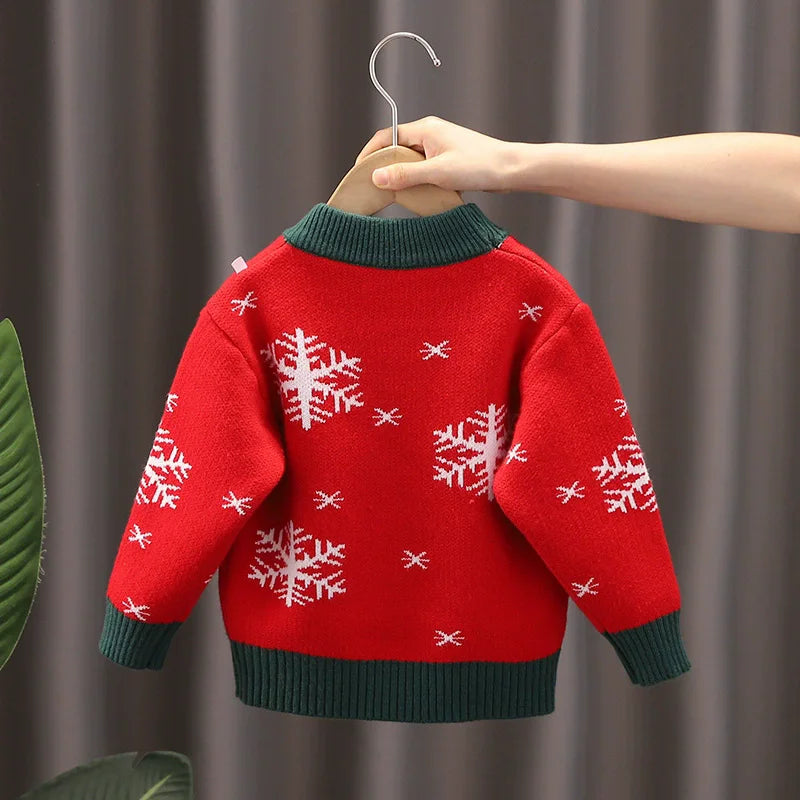 Red sweater with snowflake patterns on a hanger against a neutral background