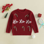Red Christmas Jumper with 'Ho Ho Ho' text and candy cane decorations on a beige background with Christmas-themed items.