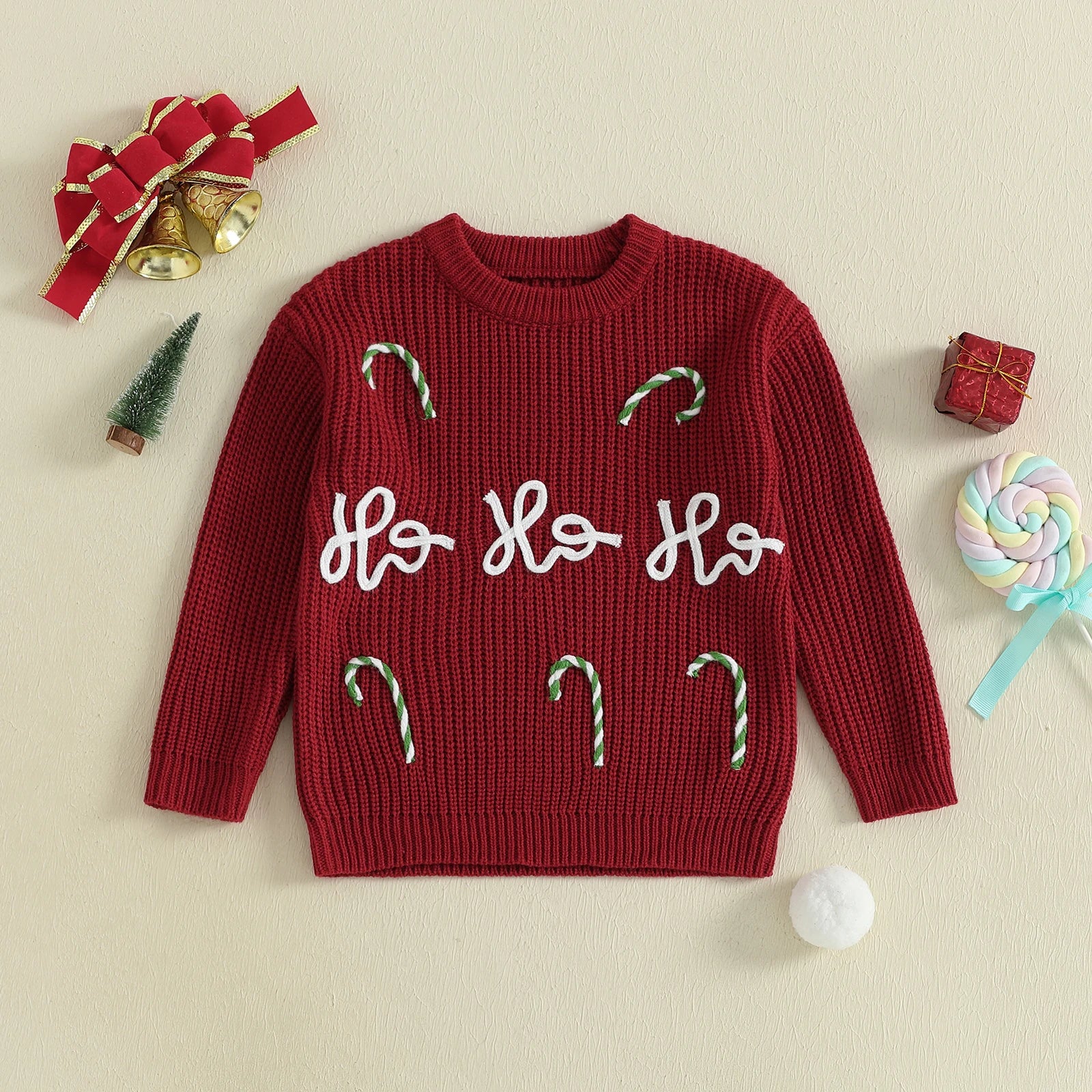 Red Christmas Jumper with 'Ho Ho Ho' text and candy cane decorations on a beige background with Christmas-themed items.