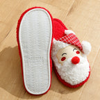 Red and white slipper with Santa Claus face design on a wooden floor